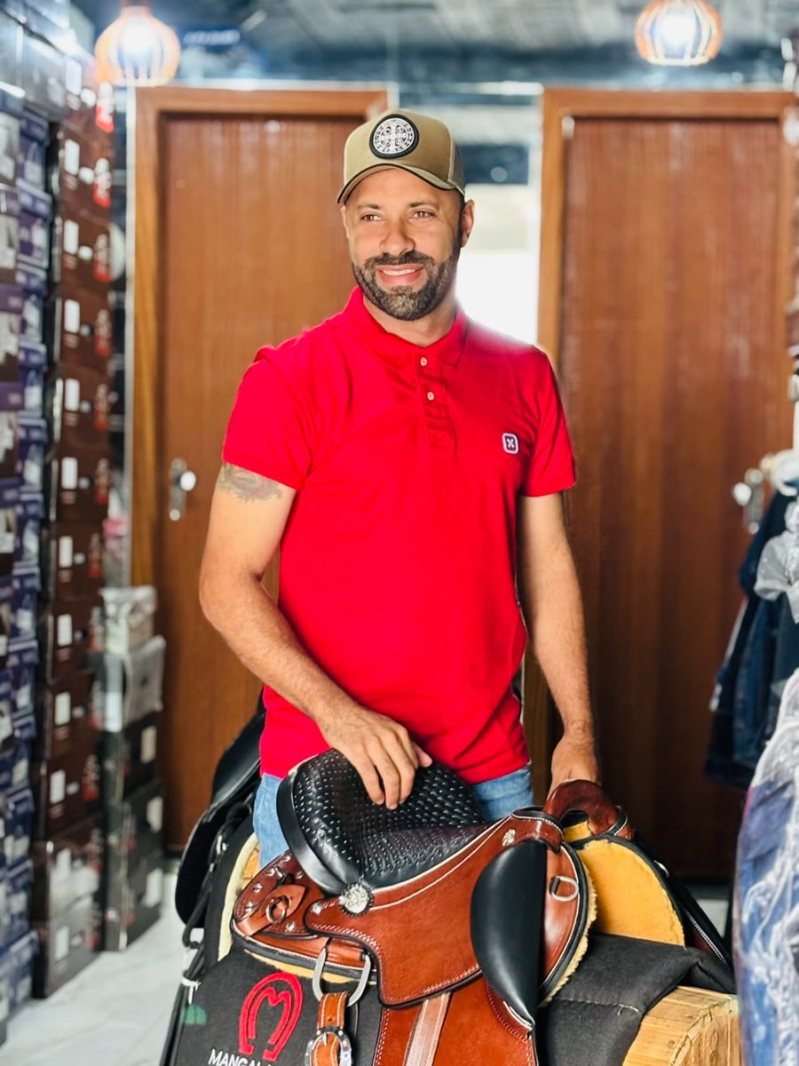 Wesley na loja com chapéus e moda country